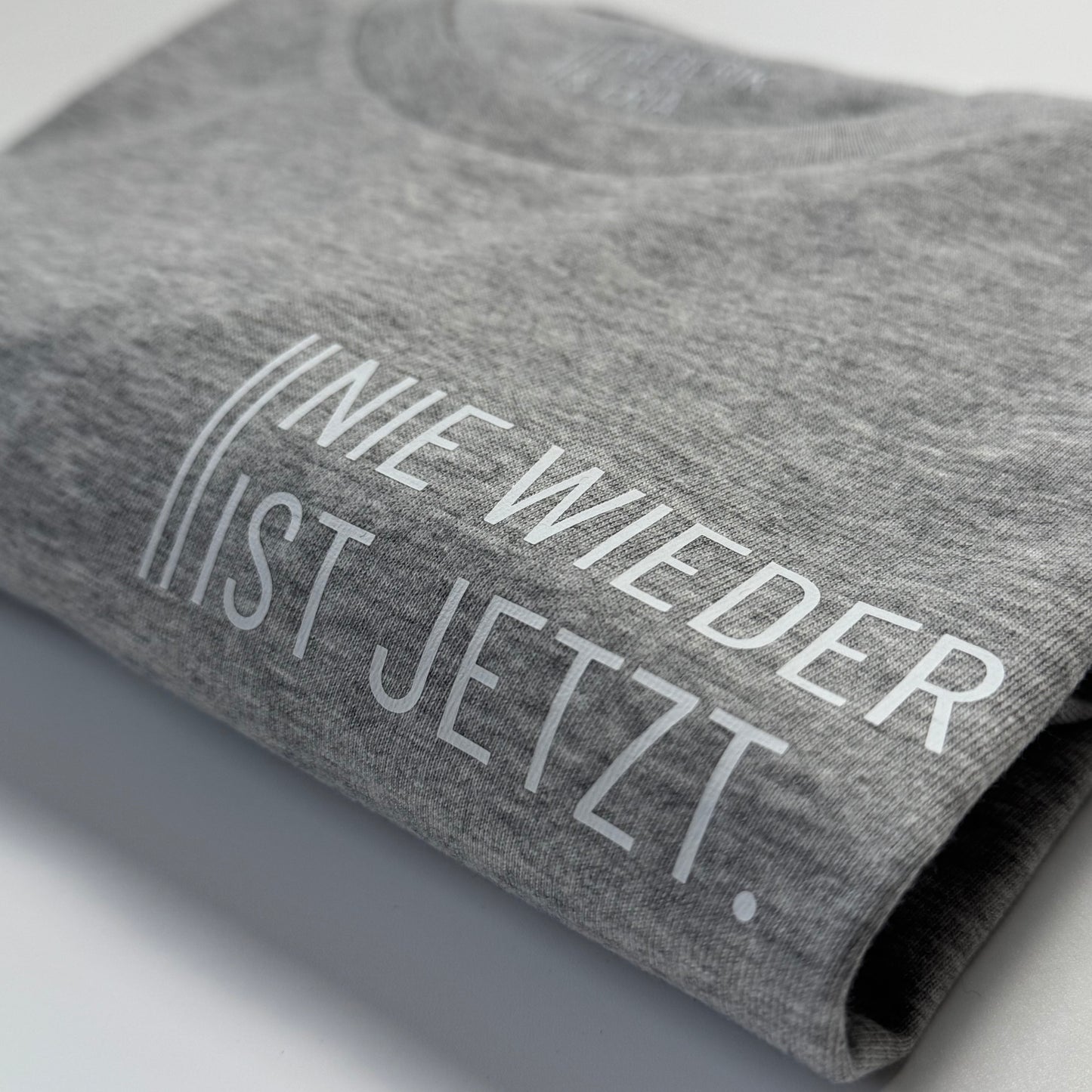 T-Shirt Unisex 'Nie wieder ist jetzt.': grau / weiß