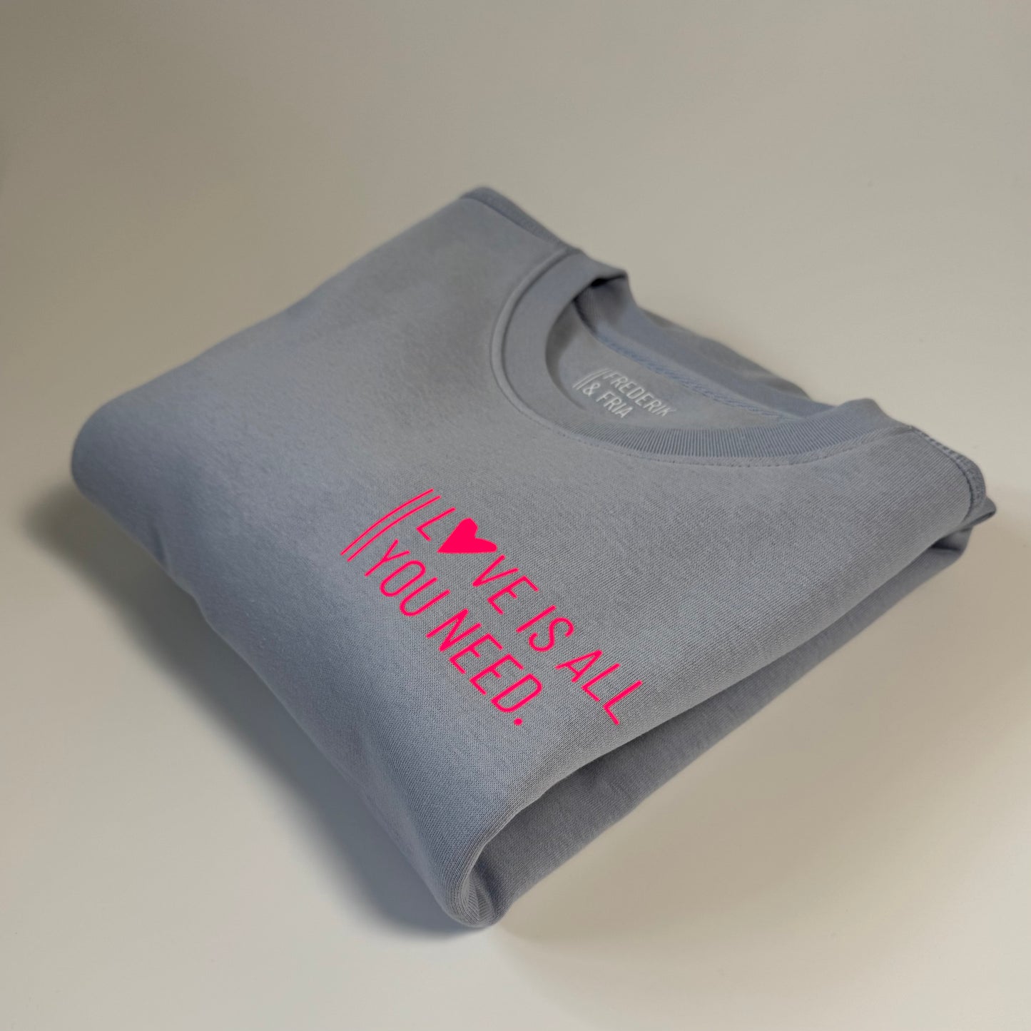 Sweatshirt Unisex 'Love is all you need.': Serene Blue / Neon Pink