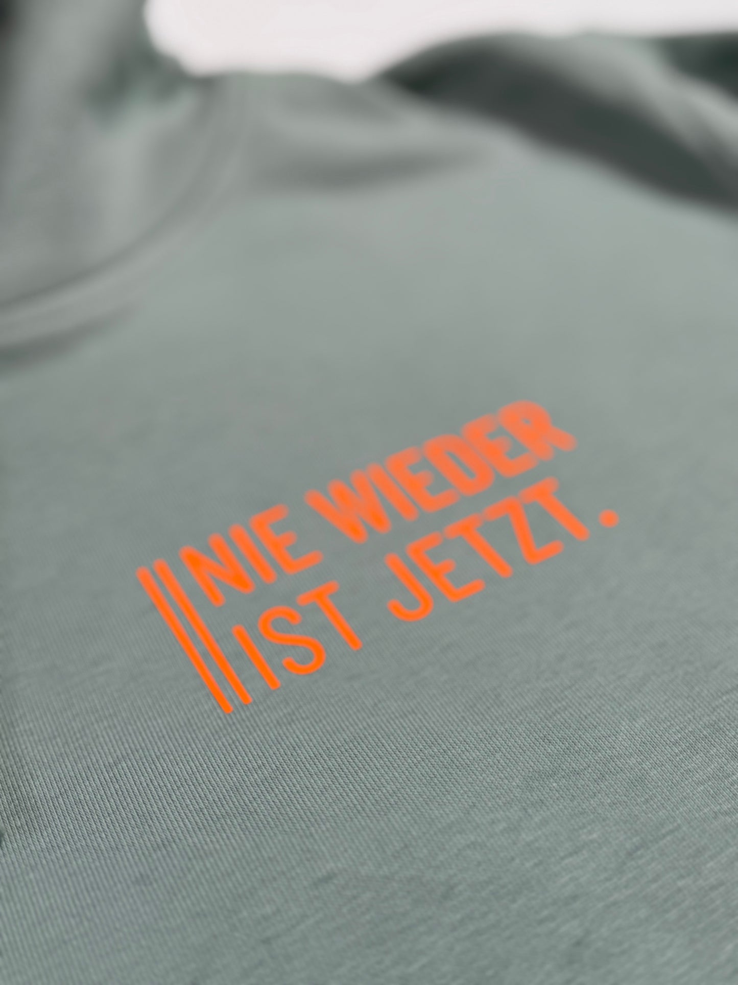 Hoodie Unisex 'Nie wieder ist jetzt.': Aloe / Neon Orange
