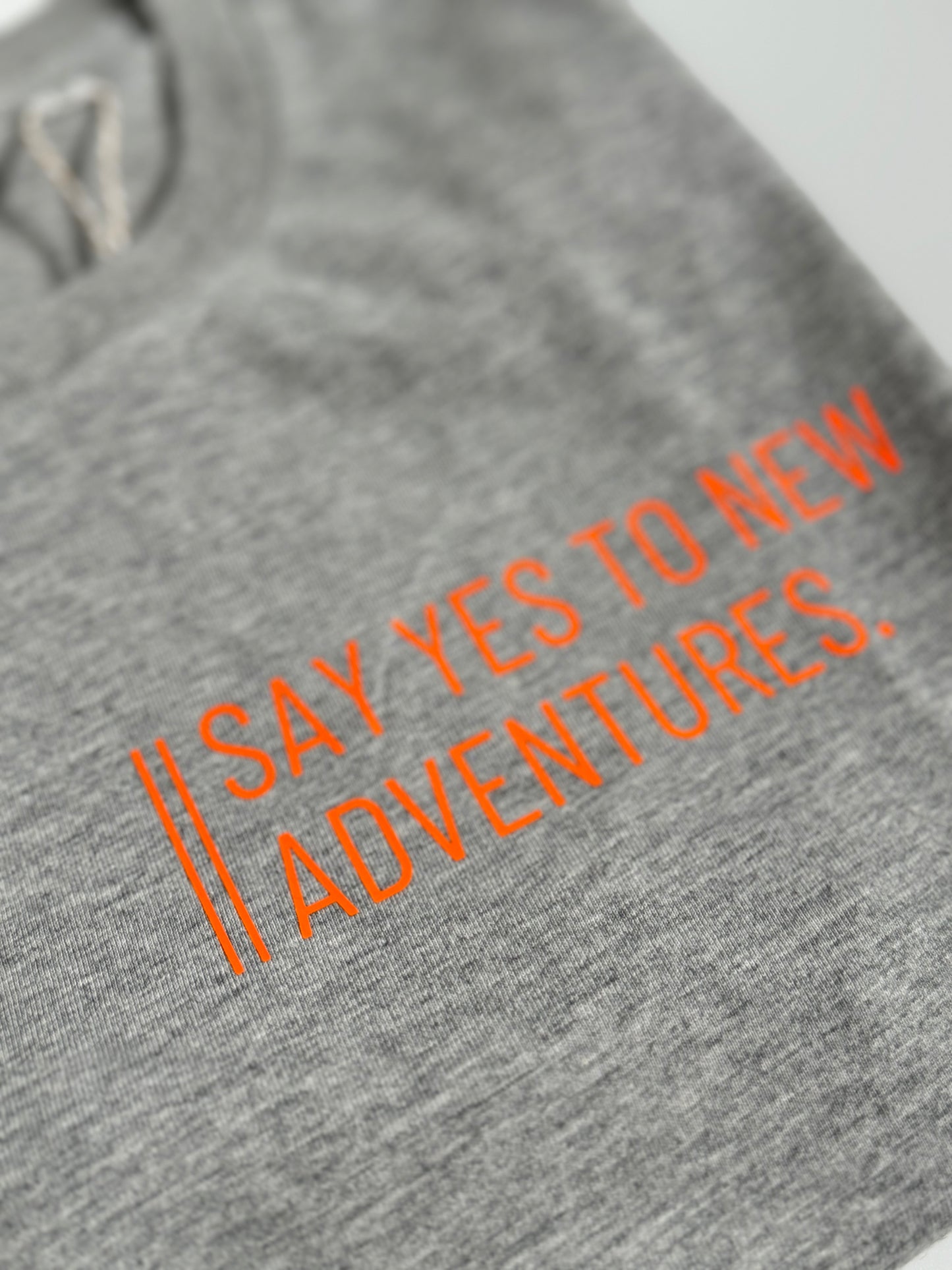 T-Shirt Unisex 'Say yes to new adventures.': grau / neon orange