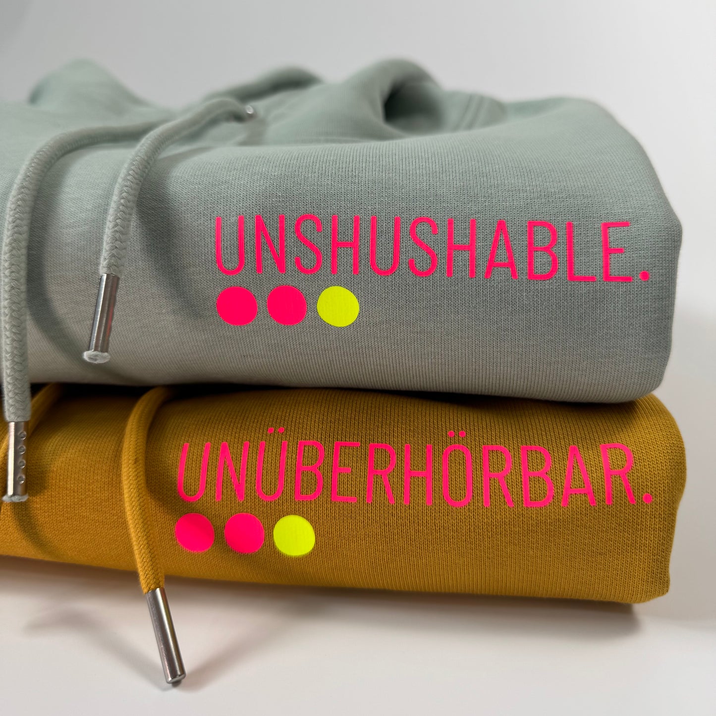Hoodie Unisex 'Unshushable / Unüberhörbar.': Senf, Aloe / Neon Pink