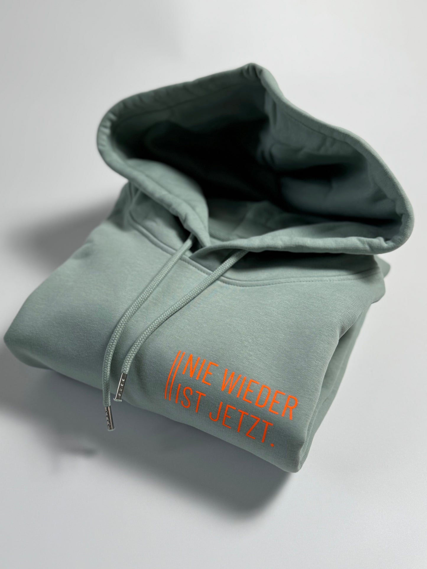 Hoodie Unisex 'Nie wieder ist jetzt.': Aloe / Neon Orange