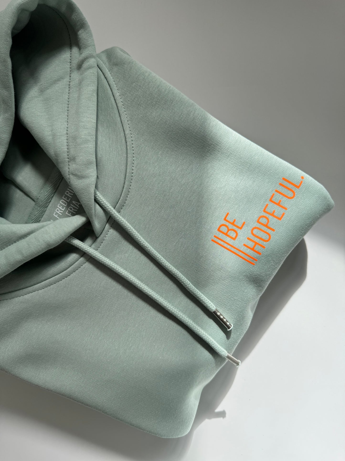 Hoodie Unisex 'Be hopeful.': Aloe / Neon Orange