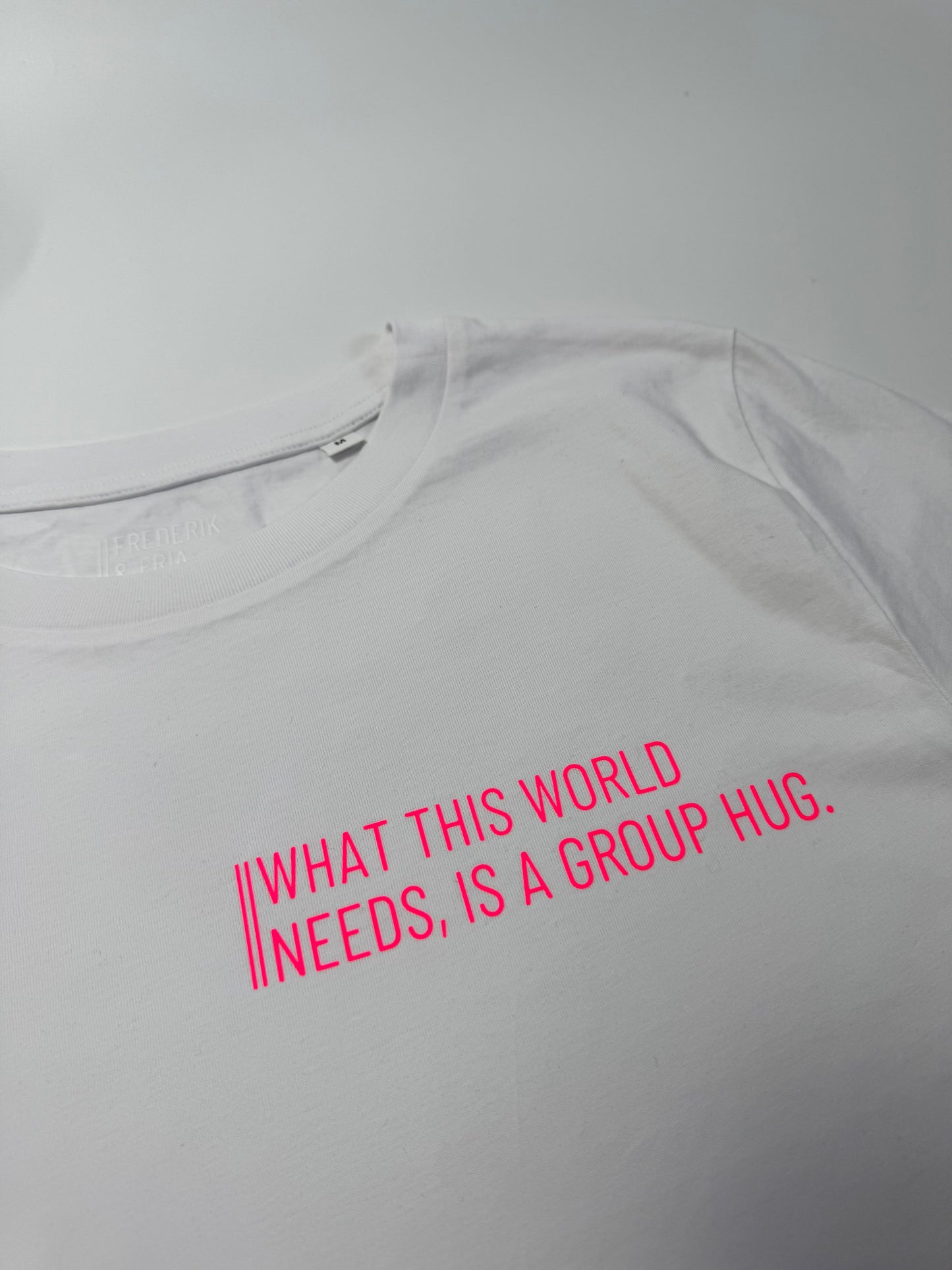 T-Shirt, Frauen, ‚What this world needs, is a group hug.‘, Weiß / Neon Pink